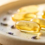 Capsulas softgel douradas de vitamina D banhadas pela luz do sol da manha, a vitamina do sol