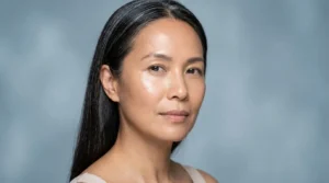 Mulher madura de pele hidratada em luz azul-acinzentada